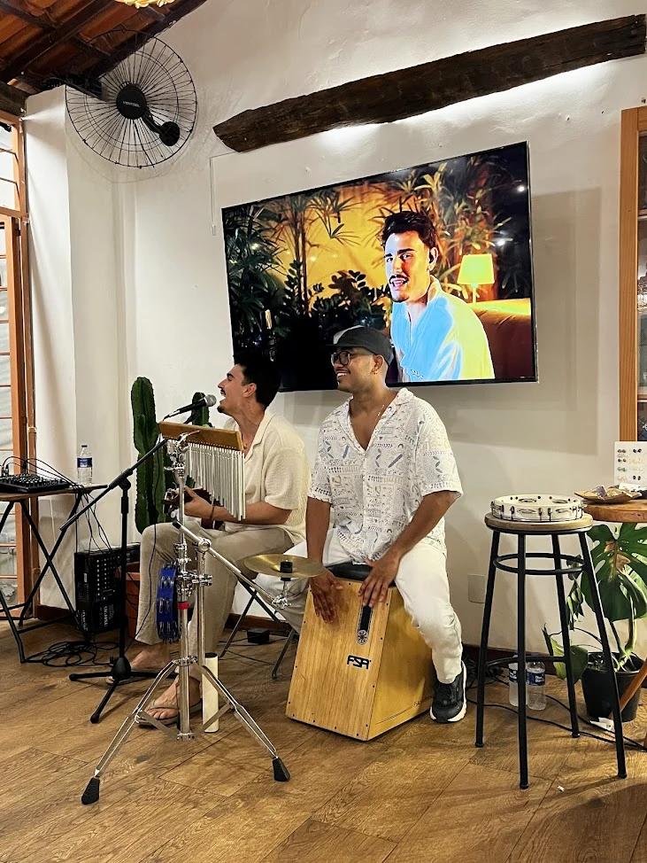 JHACA em apresentação acústica com percussão.