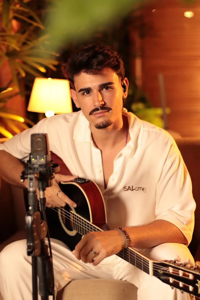JHACA com violão e microfone durante o projeto Tudo Tranquilo em São Salvador.